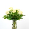 Tall clear glass vase of pale yellow roses with baby's breath accents
