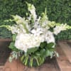 White floral arrangement in a clear glass bowl vase