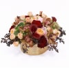 Low centerpiece of red and peach roses, burgundy calla lilies, and orchids in a gold vase