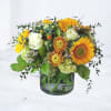 Alderfield is a warm, garden-inspired arrangement featuring vibrant sunflowers, striking pincushion protea