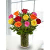 Mixed-color roses arranged in a clear glass vase on a white table