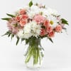 Pink roses and white daisies in a clear glass vase
