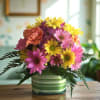 Colorful bouquet of daisies and carnations in a striped ceramic vase