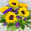 Bright and cheerful, Sunflower Serenade features radiant sunflowers accented with vivid purple