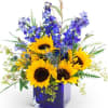 A striking mix of bright sunflowers, vibrant blue delphinium, thistle, and airy