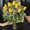 Yellow roses arranged in a clear glass vase with small white filler flowers