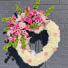 A tender heart-shaped standing spray in soft pinks, whites, lavender accents and