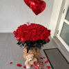 Basket of red roses with heart balloons, teddy bear, and candy box