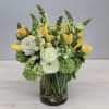 This a vibrant and cheerful arrangement featuring yellow tulips and fresh green