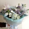 A cool, airy mix of white and lavender flowers makes this hand-tied