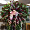 A striking and elegant large standing spray featuring rich red roses, beautifully