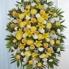 A bright and graceful standing spray designed to convey warmth, remembrance, and