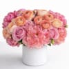 An exquisite composition of blush, coral, and soft peach tones, this arrangement