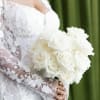 Bride holding a bouquet of white roses