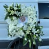 White floral funeral wreath with lilies and chrysanthemums on a stand