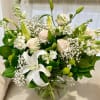 A mixed arrangement of white lilies, blush roses, green button, white filler