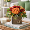 Orange and red rose arrangement in a rustic wooden box