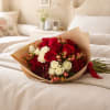 Bouquet of red and white roses wrapped in brown paper