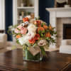 Bouquet of orange, pink, and white roses in a glass vase