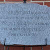 Engraved stone plaque with a religious quote on a metal stand