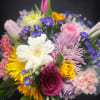 A soft pink colored floral with pops of lavender, yellow and white