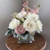 Pink and white rose bouquet in a square glass vase