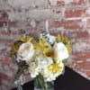 White roses and yellow alstroemeria in a glass vase
