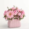 Arrangement of pink roses, Gerbera daisies, mini carnations, and waxflowers accented with