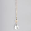 Gold chain necklace with a small heart charm and a clear teardrop crystal pendant