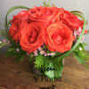 Red rose bouquet with small pink filler flowers in a vase
