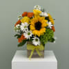 An ultra cheerful arrangement of yellow sunflowers, orange spray roses, mini green