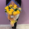 Bouquet of yellow roses wrapped in blue and clear paper