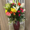 Mixed bouquet of roses, lilies, and chrysanthemums in a burgundy vase