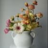 A vibrant spring arrangement designed to bring instant joy. Featuring tulips, ranunculus