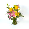 Pink lilies and yellow roses in a glass vase