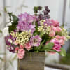 Pink and purple floral arrangement in a wooden box