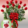 Red roses in a glass vase with baby's breath and a teddy bear inset