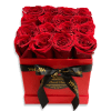Red roses arranged in a square red box with a black ribbon