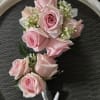 Pink rose boutonniere with small white filler flowers
