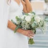 Bride holding a white rose bouquet with baby's breath and eucalyptus