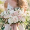 Bride holding a bouquet of pale pink and white roses
