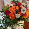 Bride holding a bouquet of orange, pink, and white flowers with trailing ribbon