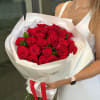 Bouquet of red roses wrapped in white paper with a red ribbon