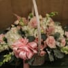 Basket of pink and white flowers with a pink ribbon bow