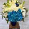 Blue hydrangeas and white lilies in a cobalt vase