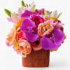 Lovely roses and orchids arranged in a modern glass cube vase. Perfect