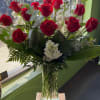 Red roses and white flowers arranged in a clear glass vase