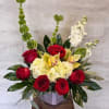 (ALL-ROUNDED) A compact, elegant floral arrangement featuring deep red roses, soft yellow