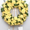 This sympathy wreath includes bright yellow roses and fluffy seasonal greens.

We include