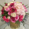 Pink and cream floral arrangement in a gold vase